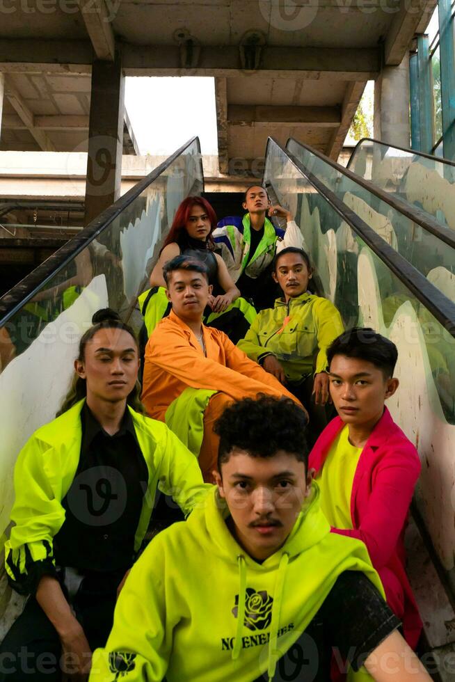 a group of Asian men are relaxing on the stairs with their friends at a university photo