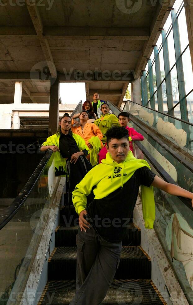 a group of Asian men in lemon green jackets are standing with their friends on the escalator photo