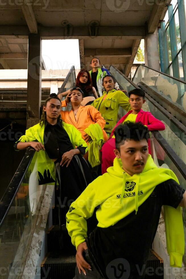 a group of Asian men in lemon green jackets are standing with their friends on the escalator photo