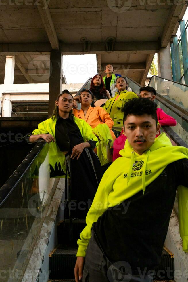 a group of Asian men in lemon green jackets are standing with their friends on the escalator photo