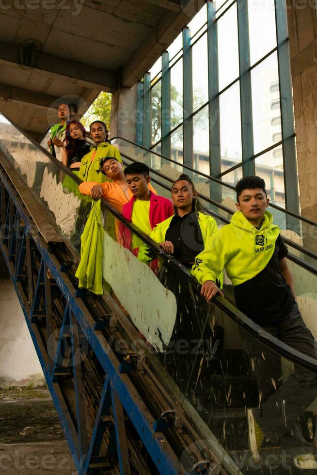 a group of Asian men in green shirts lined up on the stairs in an old building photo