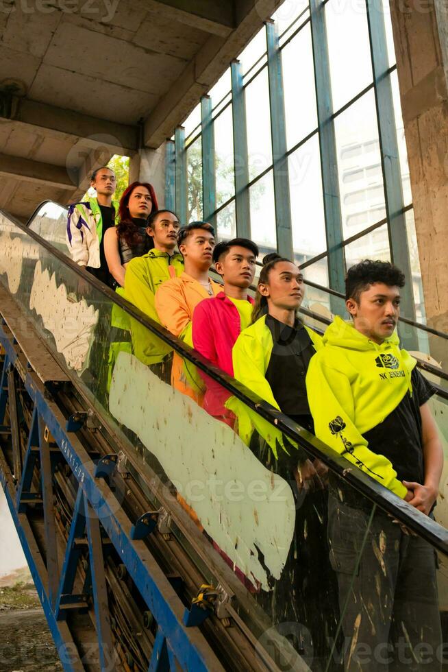 a group of Asian men in green shirts lined up on the stairs in an old building photo