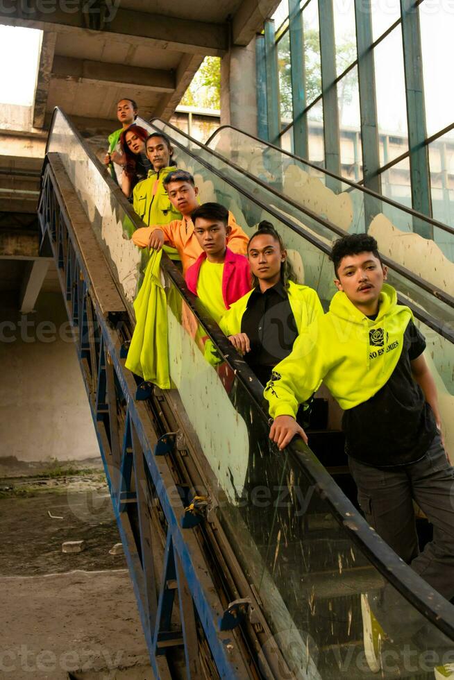 a group of Asian men in green shirts lined up on the stairs in an old building photo