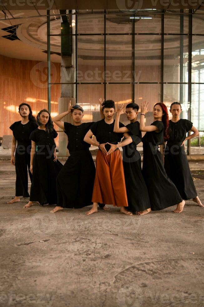 un grupo de asiático hombres en pie en frente de un antiguo edificio en varios poses foto