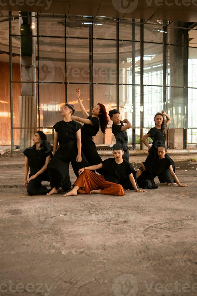 un grupo de asiático hombres en pie en frente de un antiguo edificio en varios poses foto