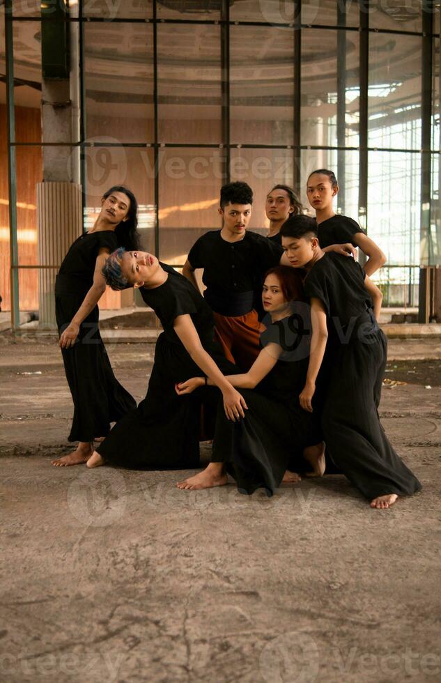 un grupo de asiático hombres en pie en frente de un antiguo edificio en varios poses foto