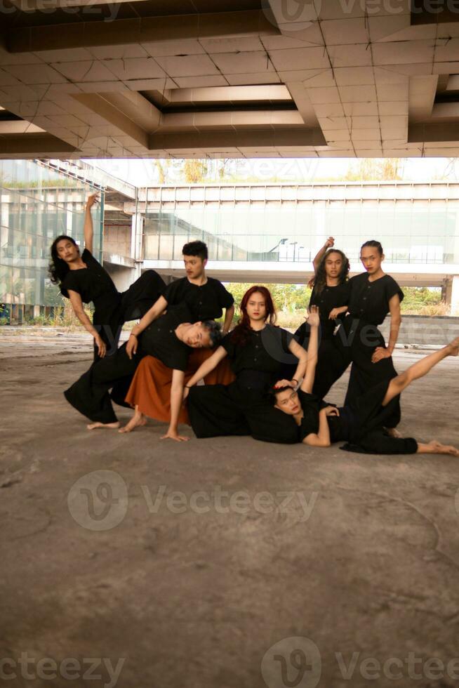 a group of Asian men posing cheerfully with their friends while wearing black photo