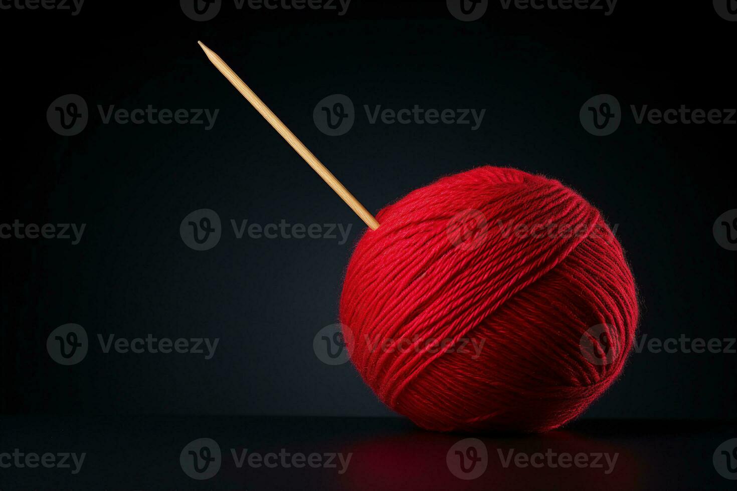 A ball of red yarn with a wooden knitting needle sticking out of it against dark background. AI Generated. photo