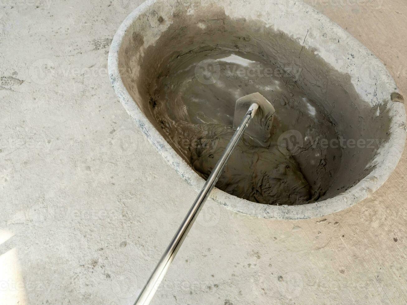 Concrete is mixed in a concrete mixing bowl photo