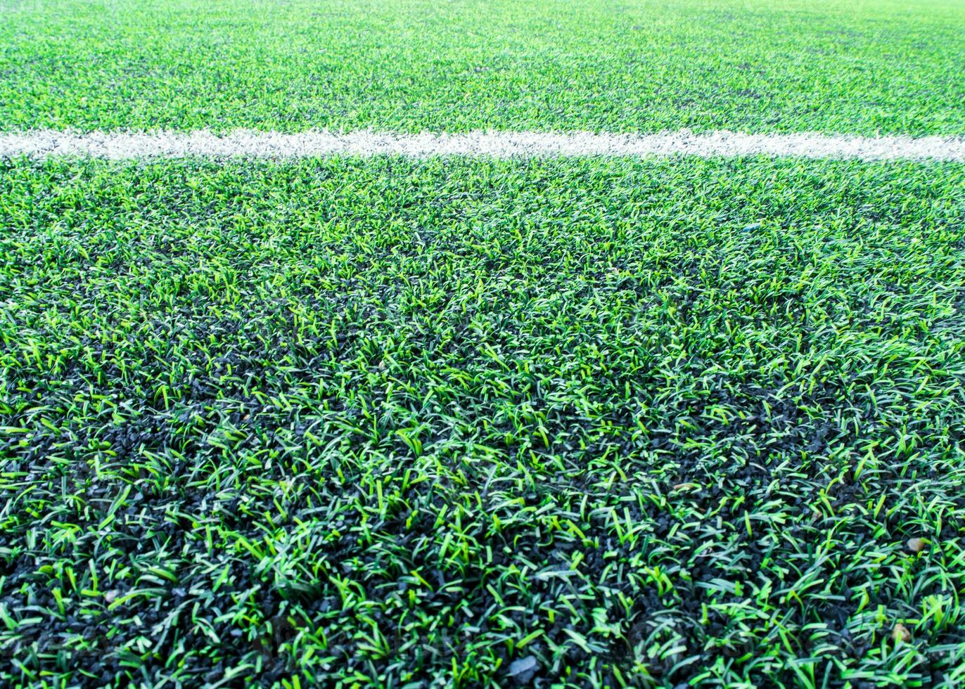 textura de césped artificial de plástico y gránulos de goma en el patio de la escuela foto