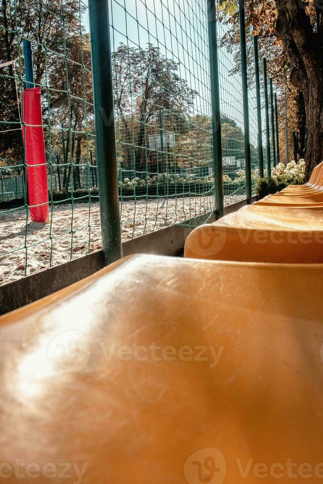 Close up yellow seats of tribune in near playground concept photo