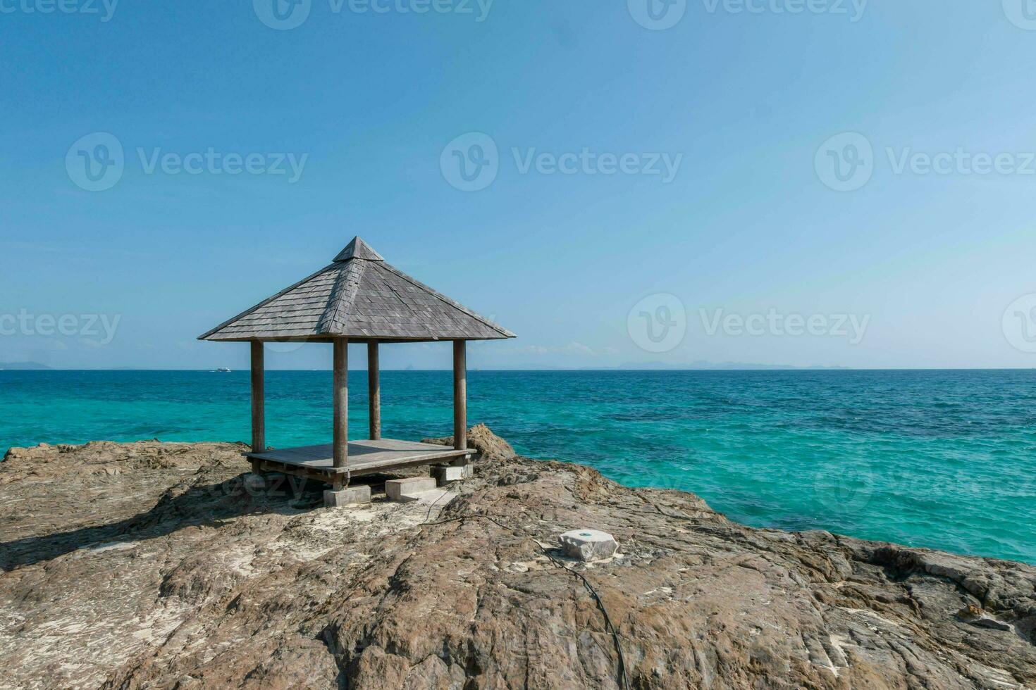 Beautiful scenery pavilion on rock coast with blue sea ocean water and sky, scenic tropical outdoor landscape coastline travel in summer with horizon bay wave, tourism sun and sunrise asia landmark photo