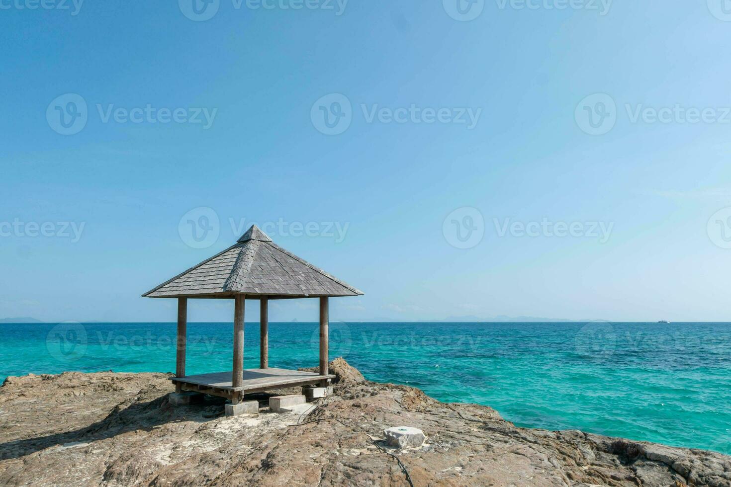 Beautiful scenery pavilion on rock coast with blue sea ocean water and sky, scenic tropical outdoor landscape coastline travel in summer with horizon bay wave, tourism sun and sunrise asia landmark photo