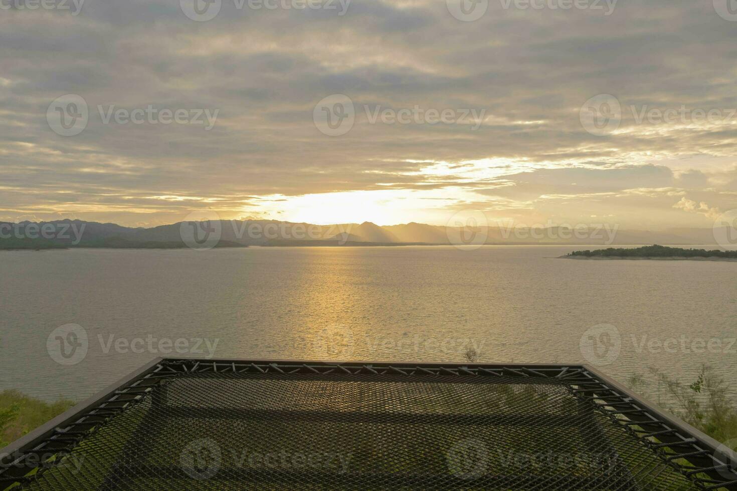 Travel for beautiful nature lake sunset with hammock, Relax vacation with landscape sky and evening sunlight, Calm outdoor holiday water reflection with cloud view background, peaceful calm horizon photo