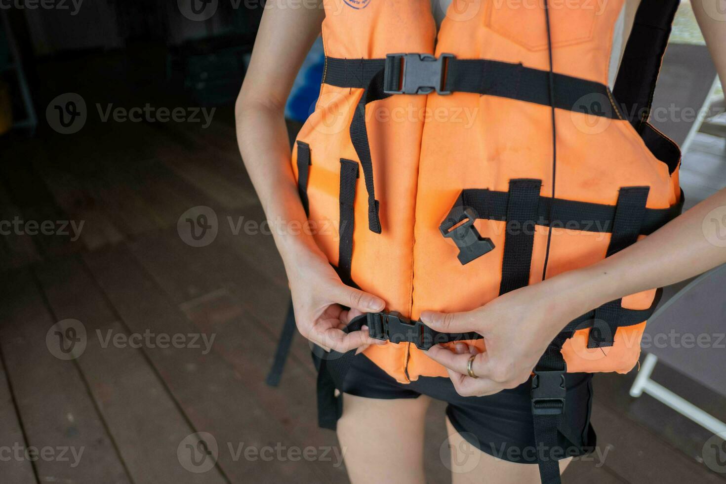 Person wear putting orange life vest jacket equipment protection to float for leisure vacation summer outdoor safety water extreme recreation, active travel precaution lifestyle rescue survival life photo