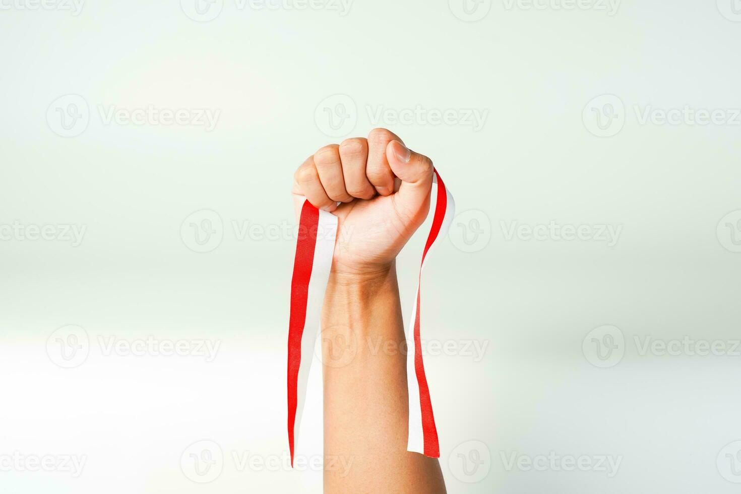 hand holding ribbon red white flag of Indonesia independence day August 17th  isolated on white background photo