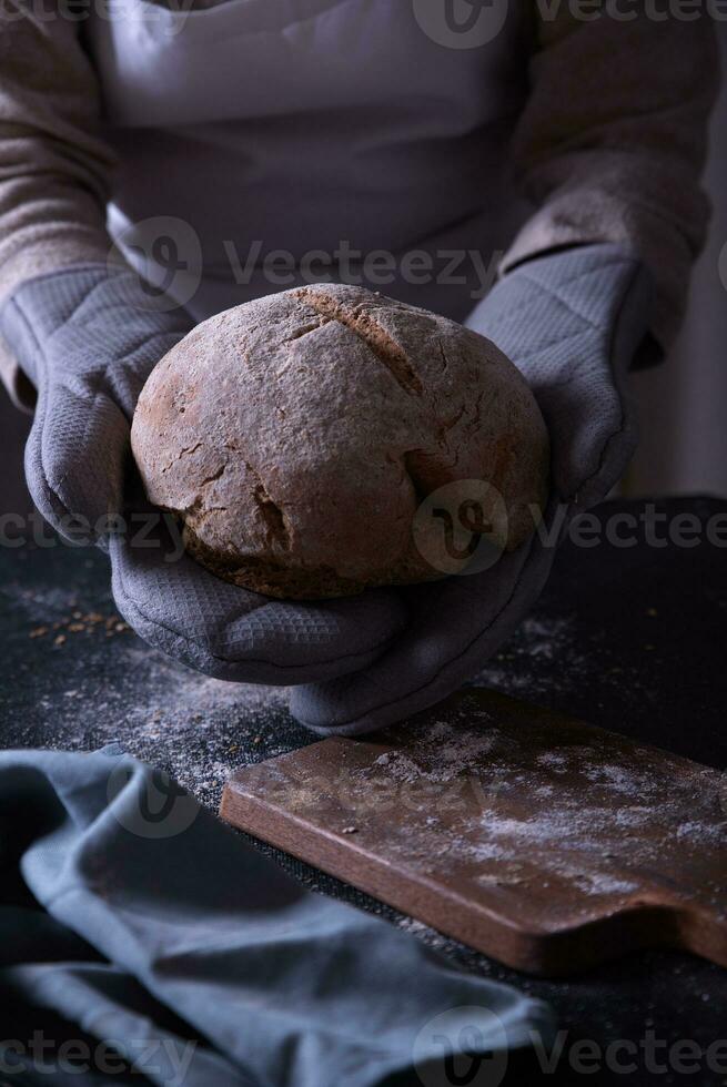 Hands leaving the prepared bread on the table. photo