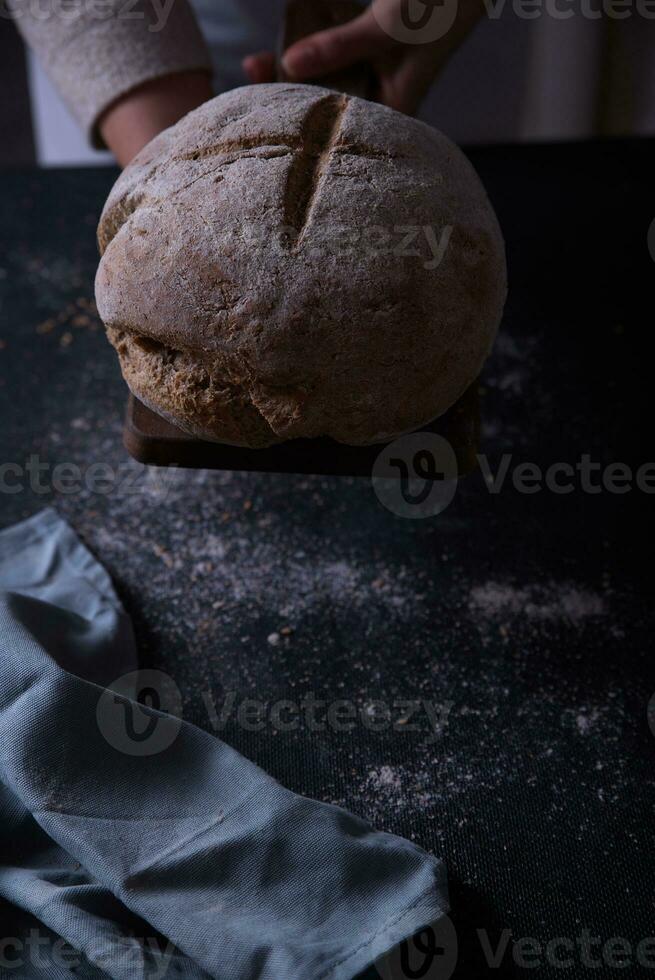 Hands leaving the prepared bread on the table. photo