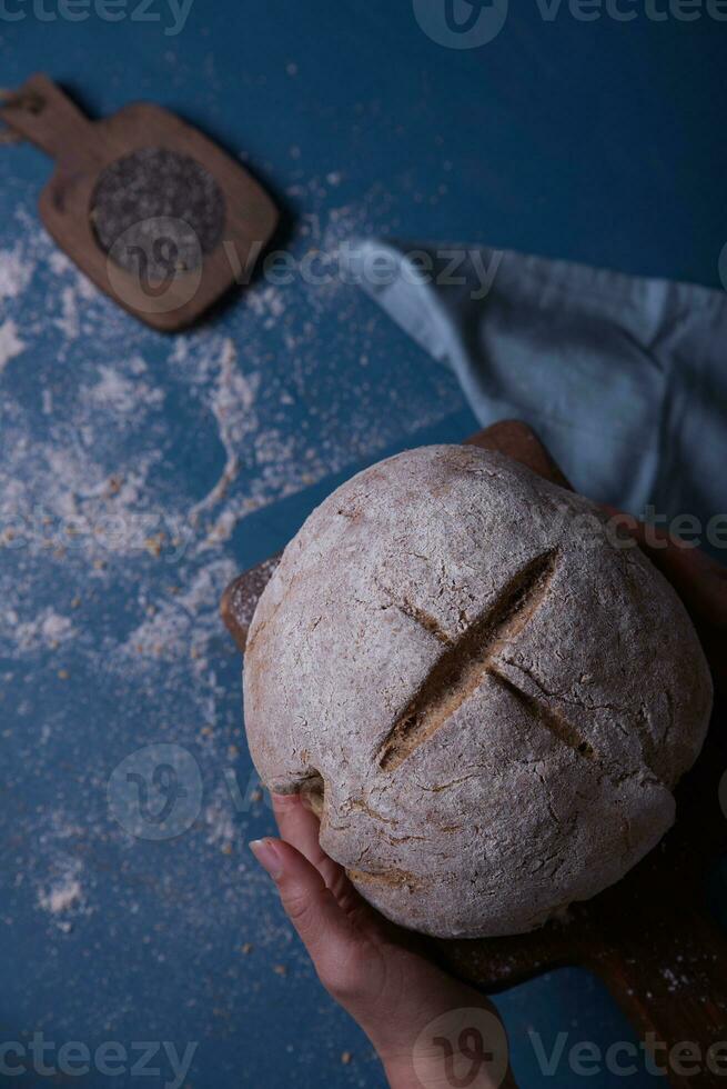 Hands leaving the prepared bread on the table. photo