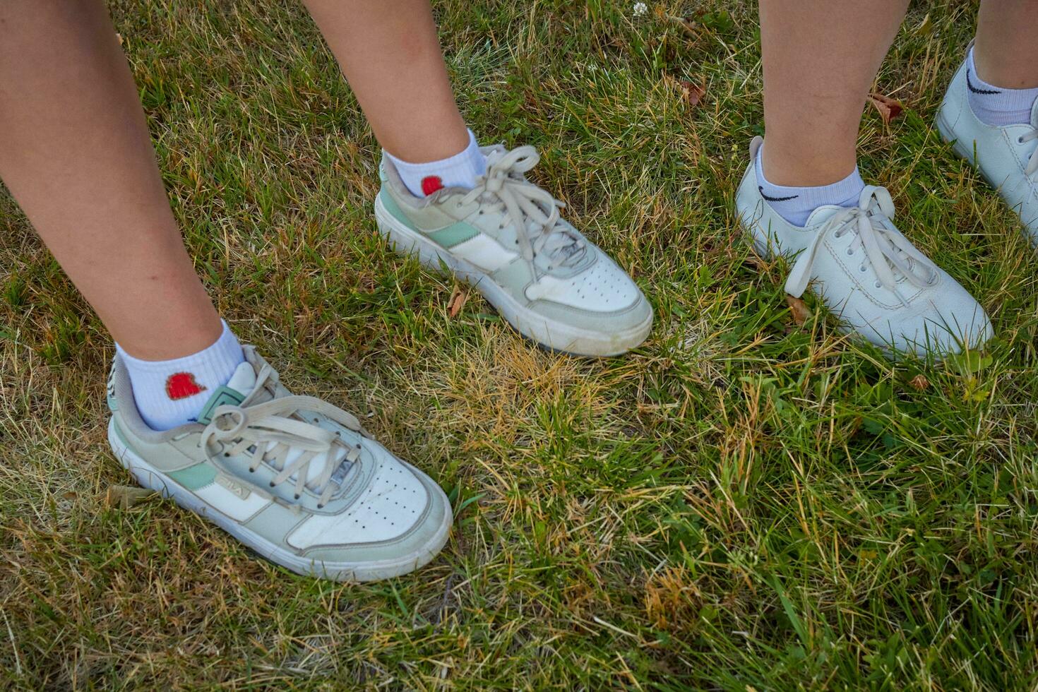 Photo of sneakers with white socks on children feet.