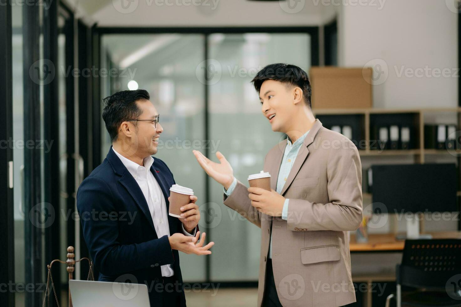 Two Asian businessman and man discuss investment project working and planning strategy with tablet laptop computer in modern office. photo