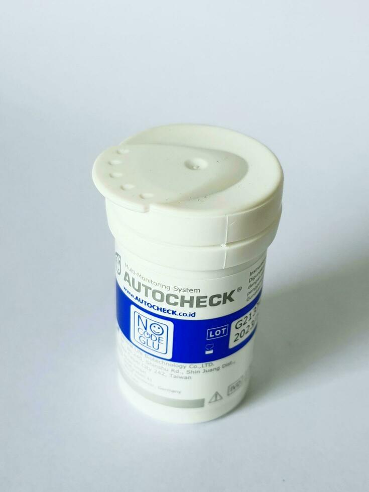 Bekasi, Indonesia on July 7 2022. Isolated white photo of a container of glucose test strips. Autocheck brand.