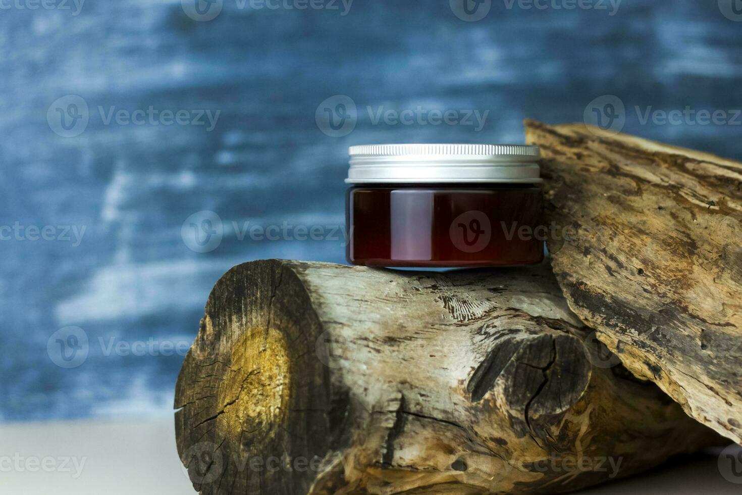 A jar of cream on the background of a dry stump and tree bark. Stylish appearance, layout, personality. Banner, a place for the text. photo