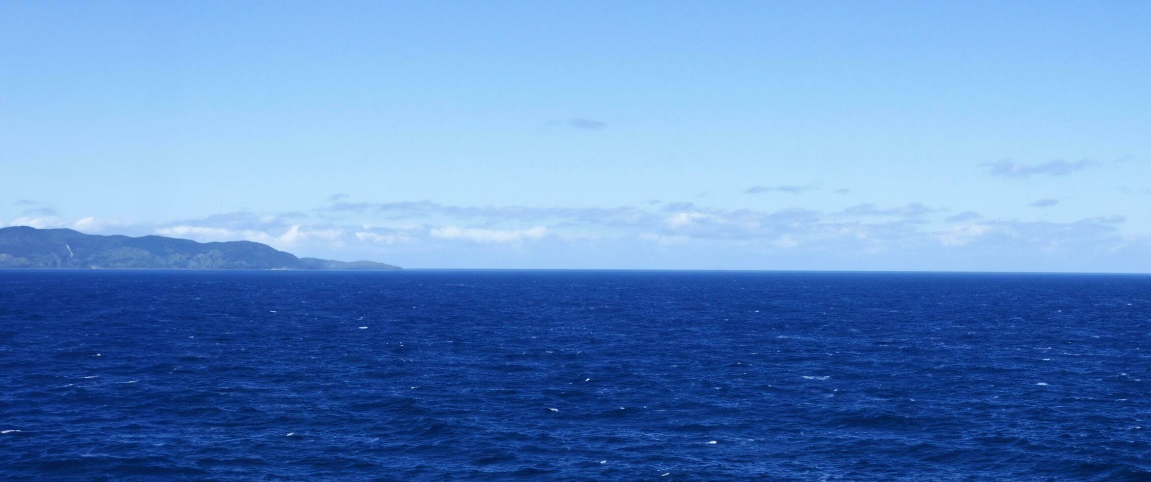 High angle view of coastline and hills calm sea photo