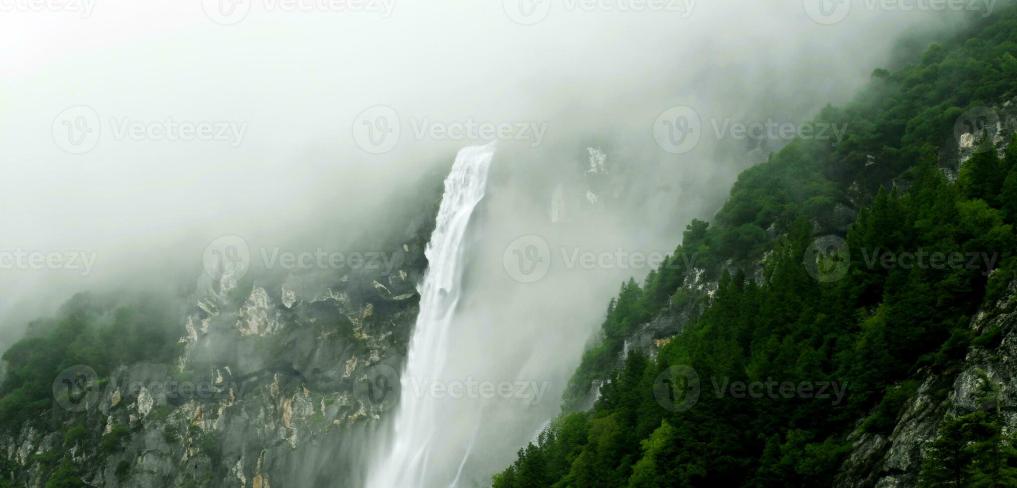 Mountain waterfall and spray waterfall background stream in nature rich in green trees photo