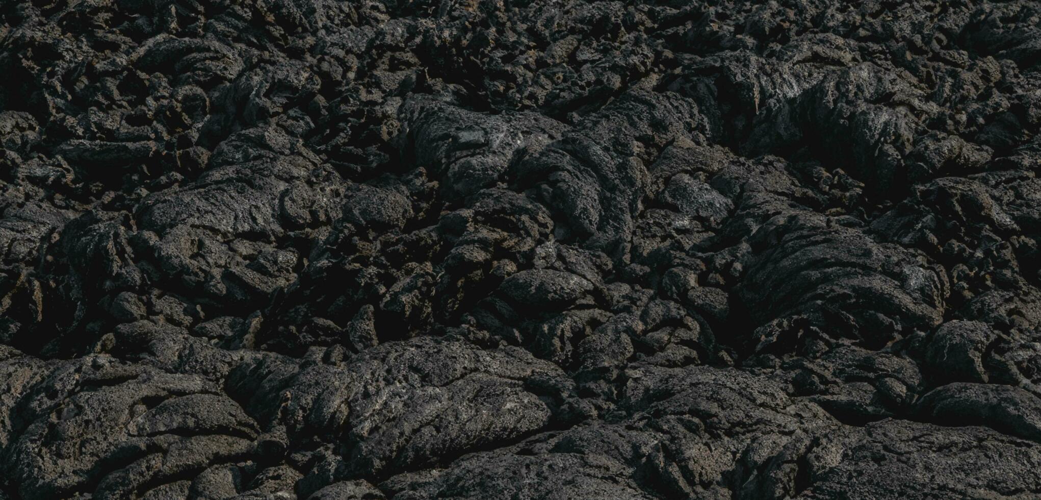 The lava surface cools and hardens into rock Clumps of dark black lava photo