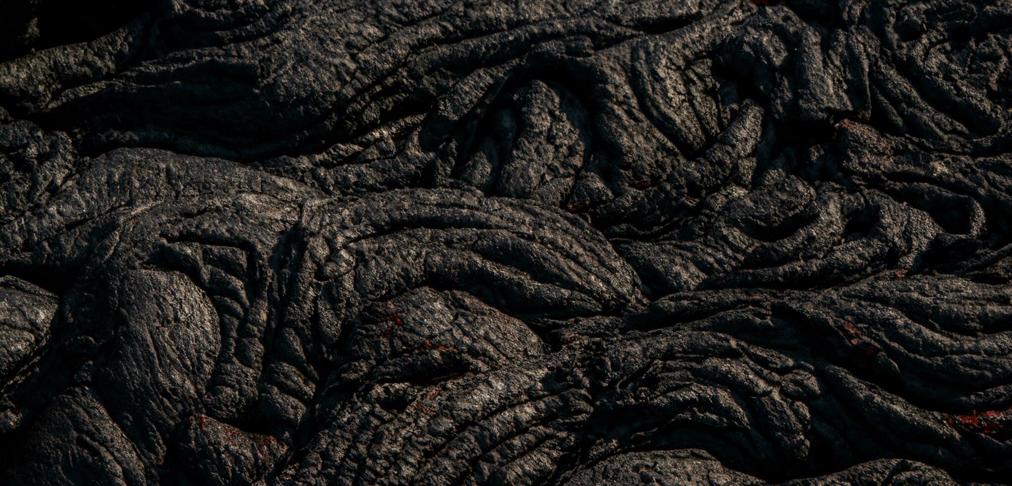The lava surface cools and hardens into rock Clumps of dark black lava photo