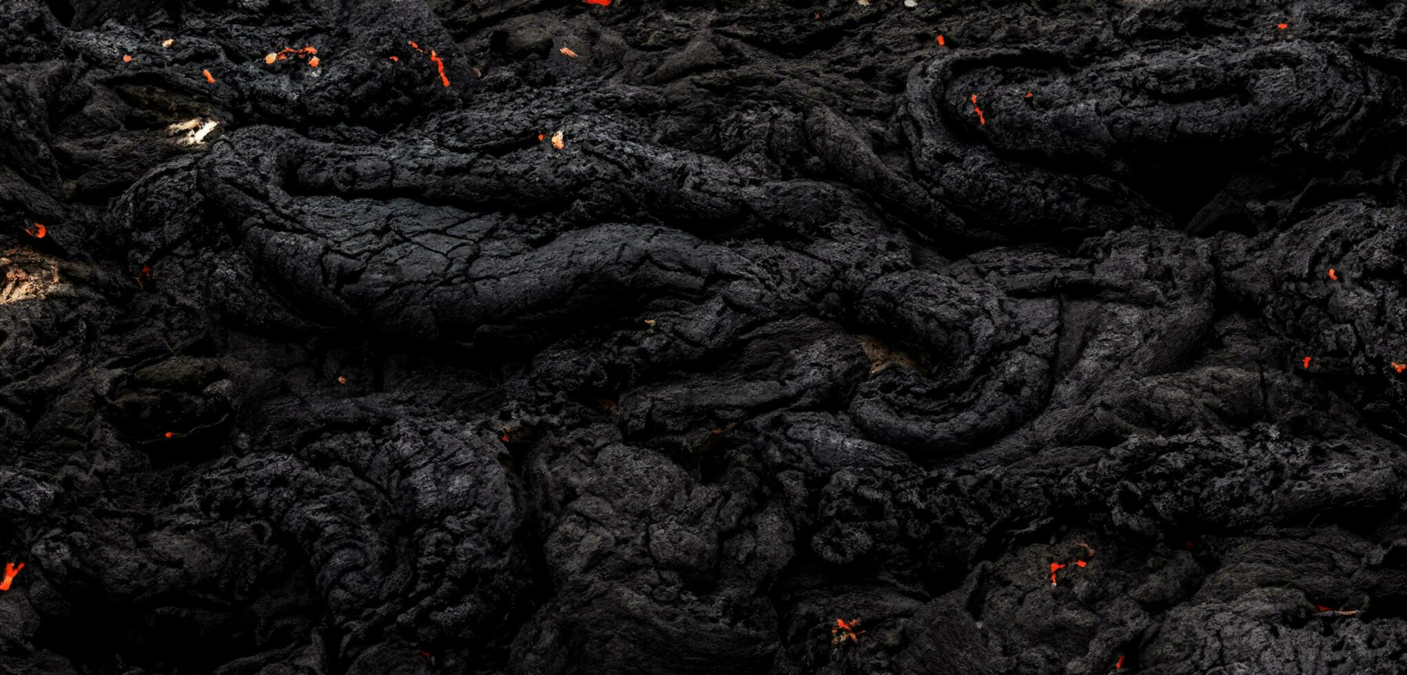 The lava surface cools and hardens into rock Clumps of dark black lava photo