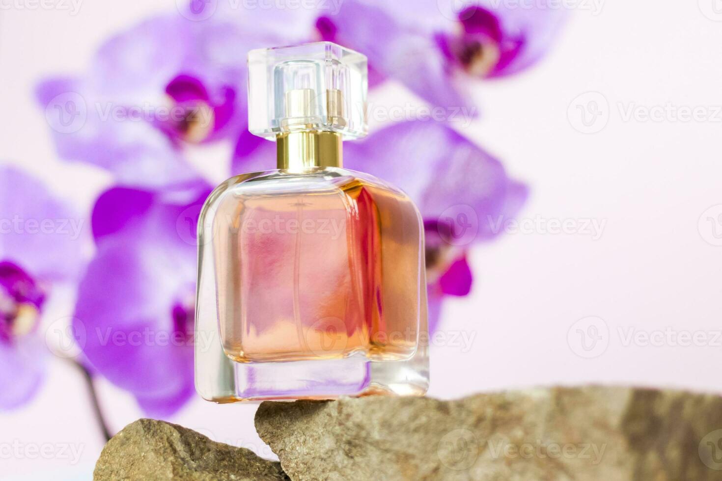 un perfume botella soportes en un Roca en contra un antecedentes de hermosa orquídeas. elegante apariencia, disposición, personalidad. bandera, un sitio para el texto. foto