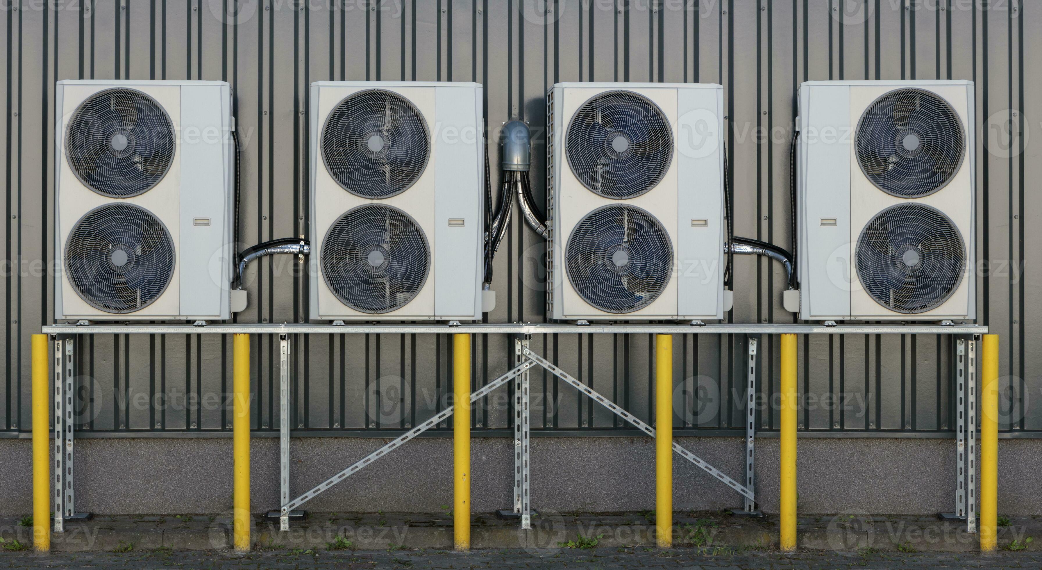 A series of split air conditioner condensers mounted on a building wall