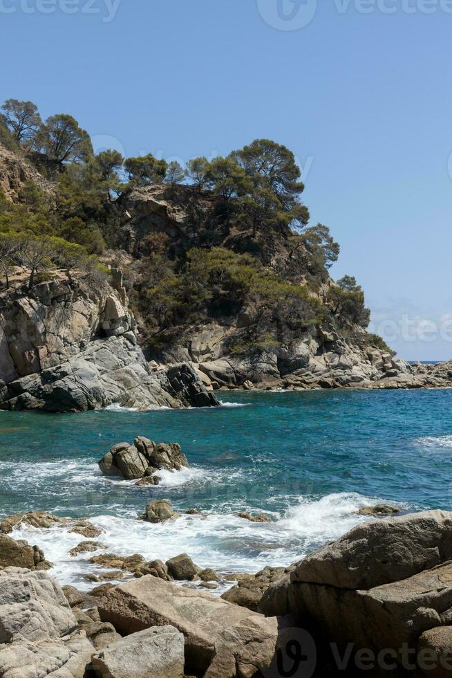 Idyllic Spanish Beach with Rocky Coastline, Vertical View photo