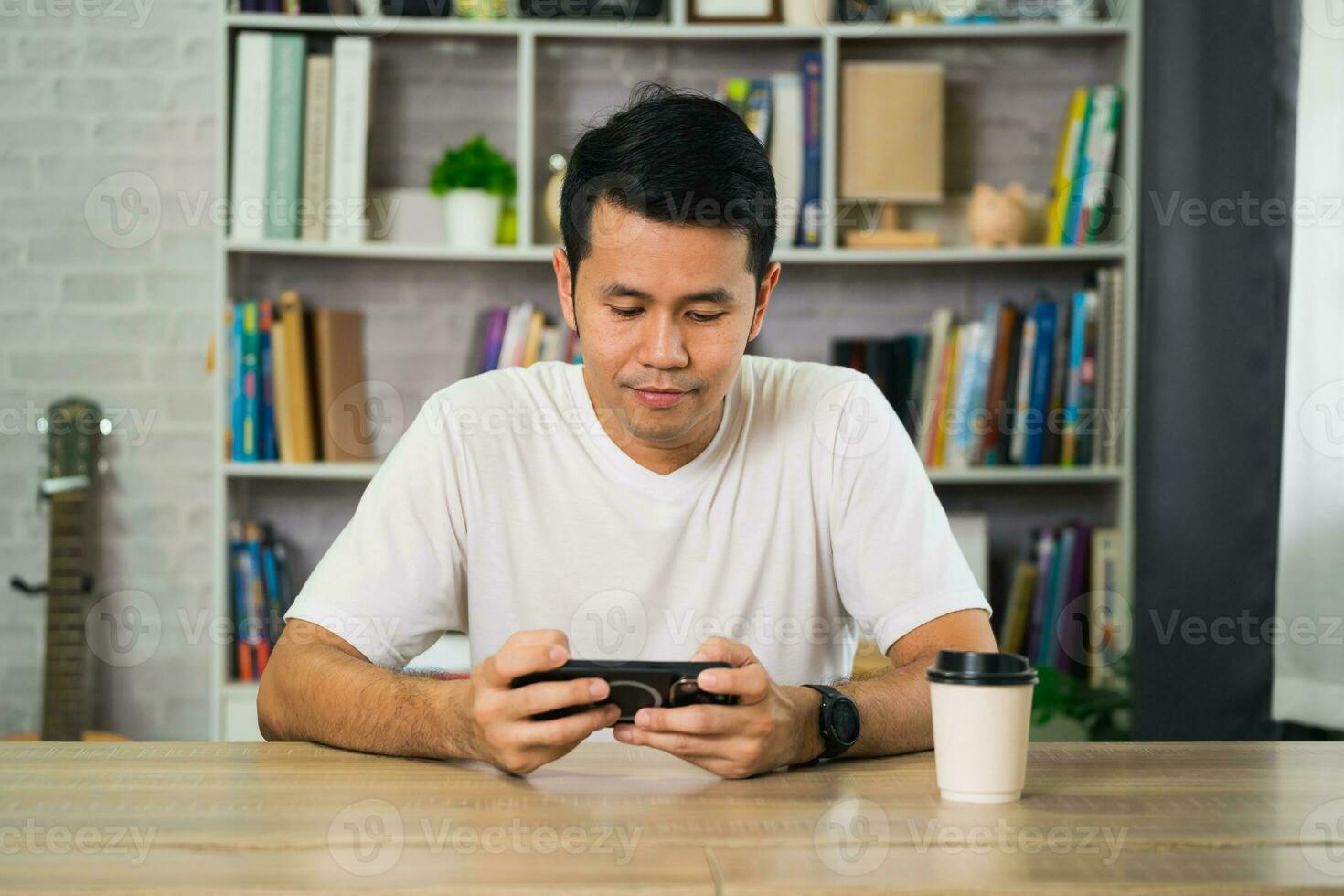 Freelance man working or chat text message with mobile successful cheerful, sitting at wooden table. Pleasant happy man communicating in social network, conferrence vdo call. Business social concept. photo