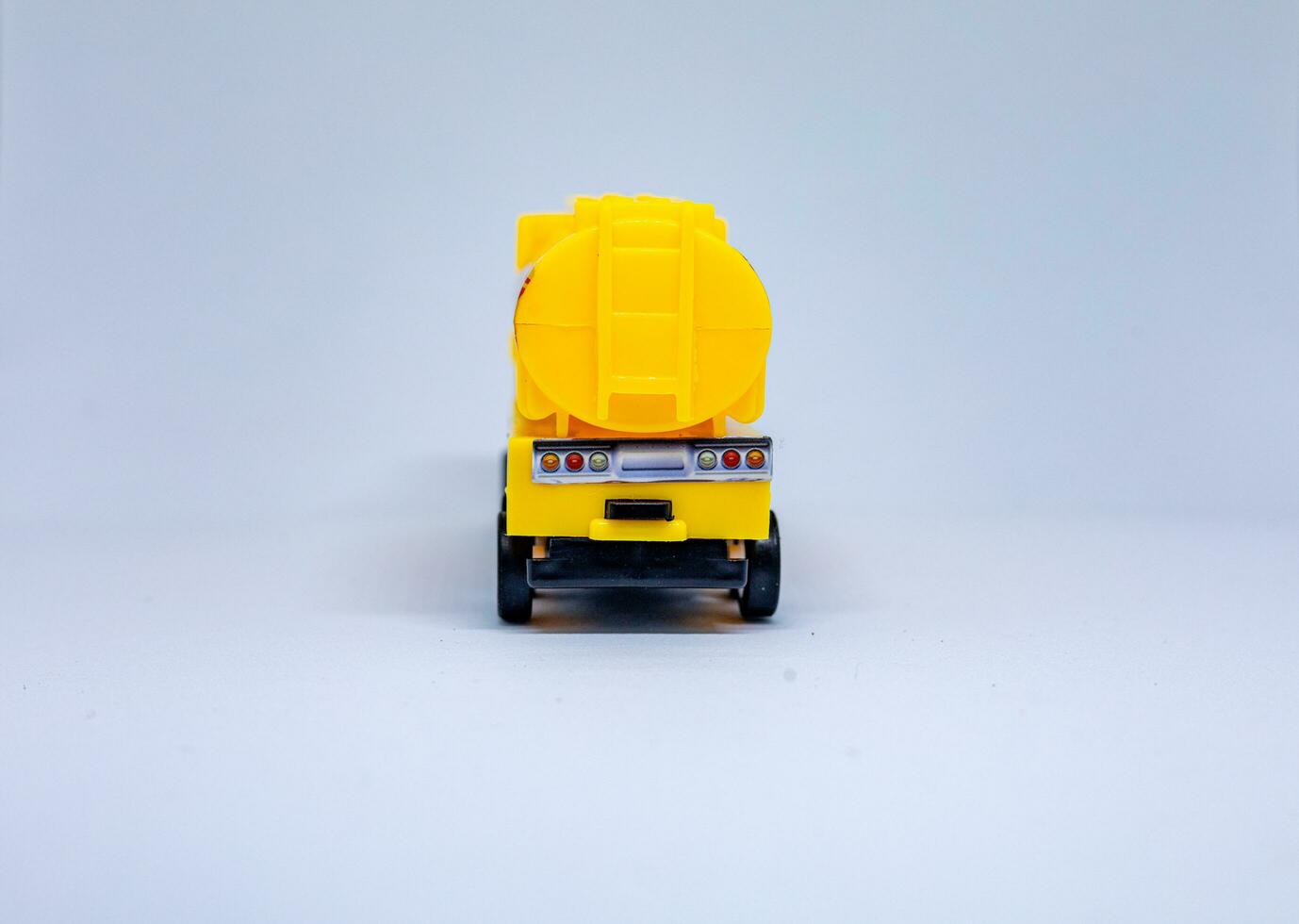 Yellow toy cement mixer truck on white background photo