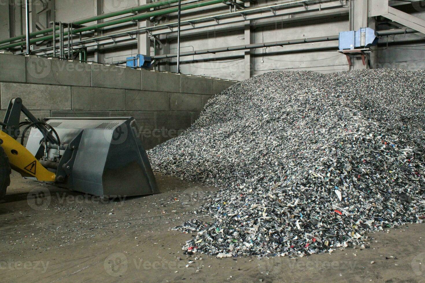Shredded plastic pieces prepare for recycling. Raw cables material for reproduction. Sorting garbage on waste plant. Pile of scrap bottles on trash storage factory. Environmental concept photo