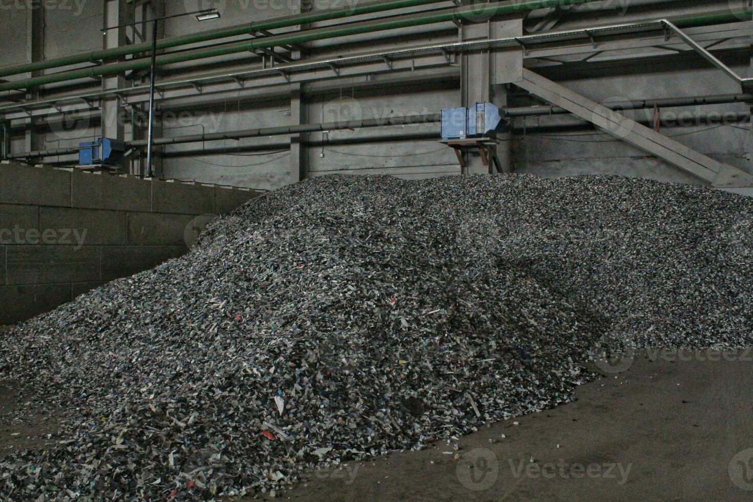 Shredded plastic pieces prepare for recycling. Raw cables material for reproduction. Sorting garbage on waste plant. Pile of scrap bottles on trash storage factory. Environmental concept photo