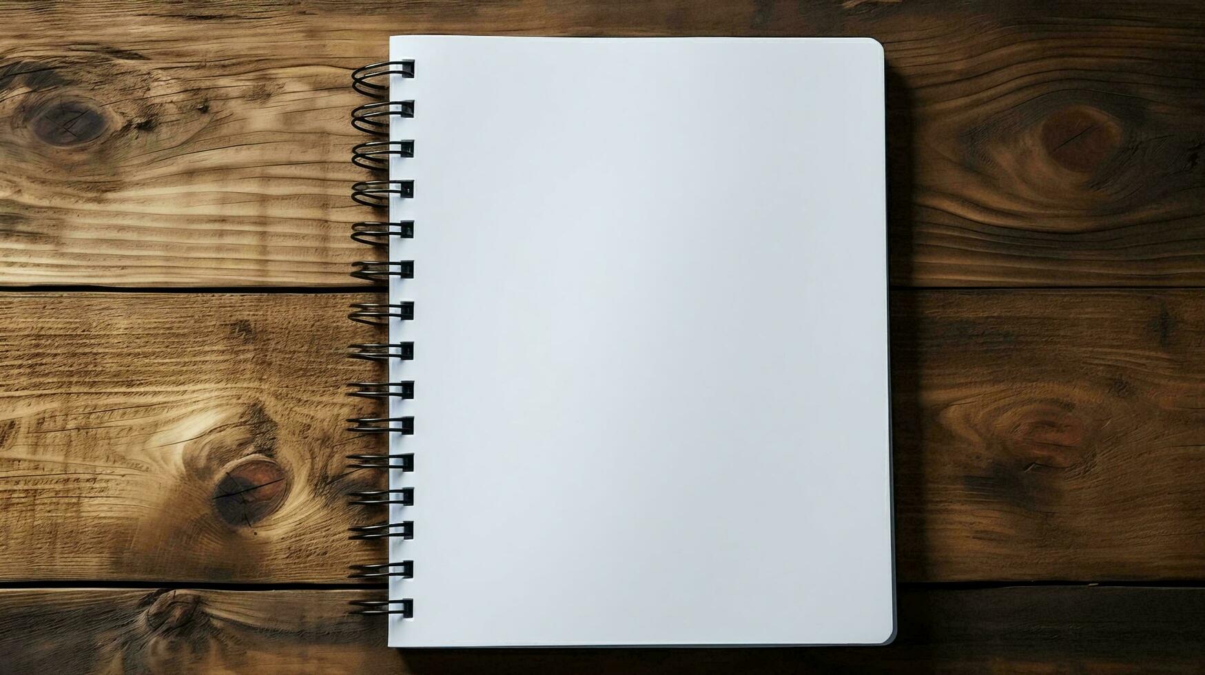 A white blank notepad with pages lies on a wooden table and copy space photo