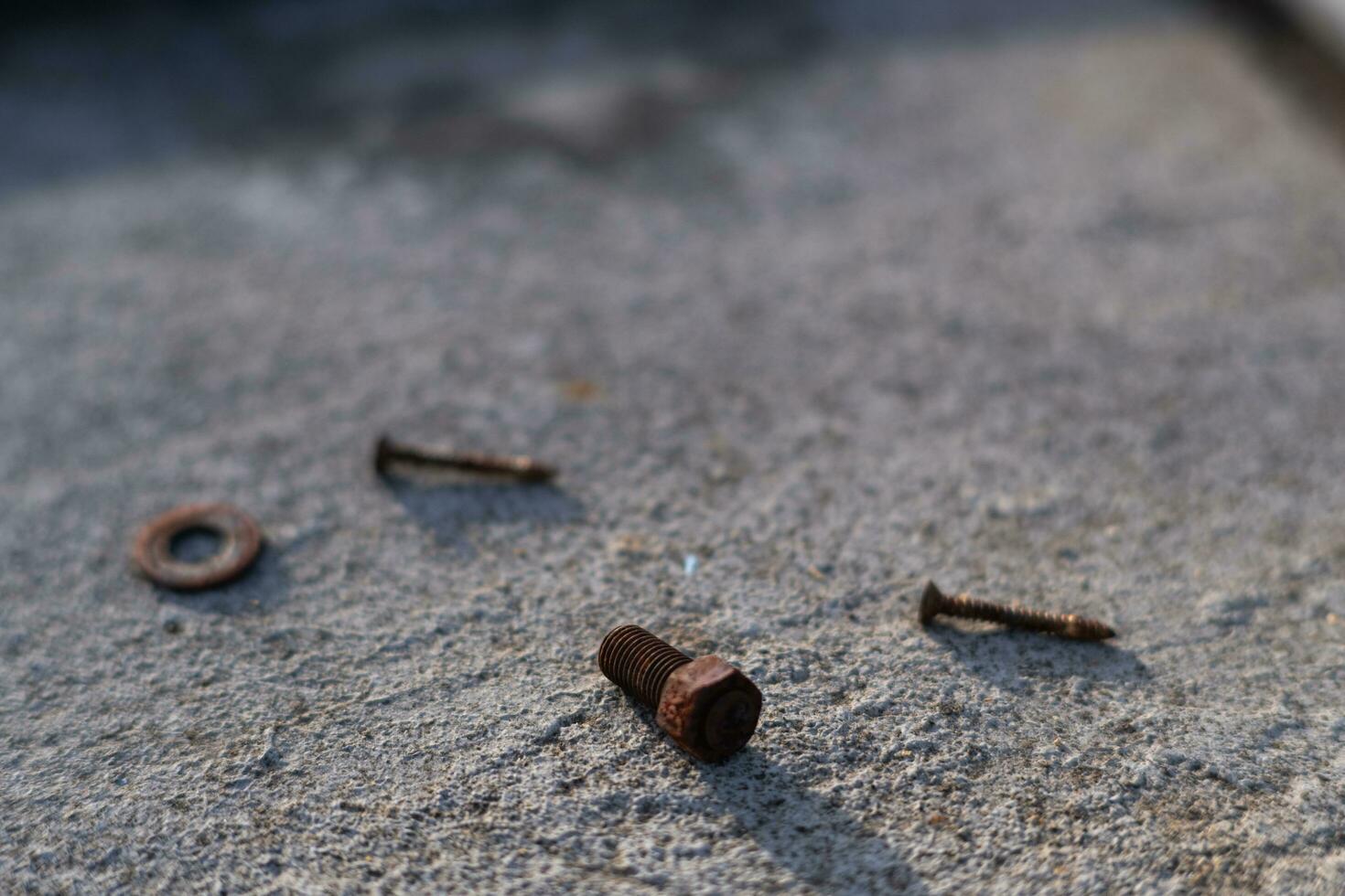 Rusty bolts and screws were scattered on the cement floor. white background photo