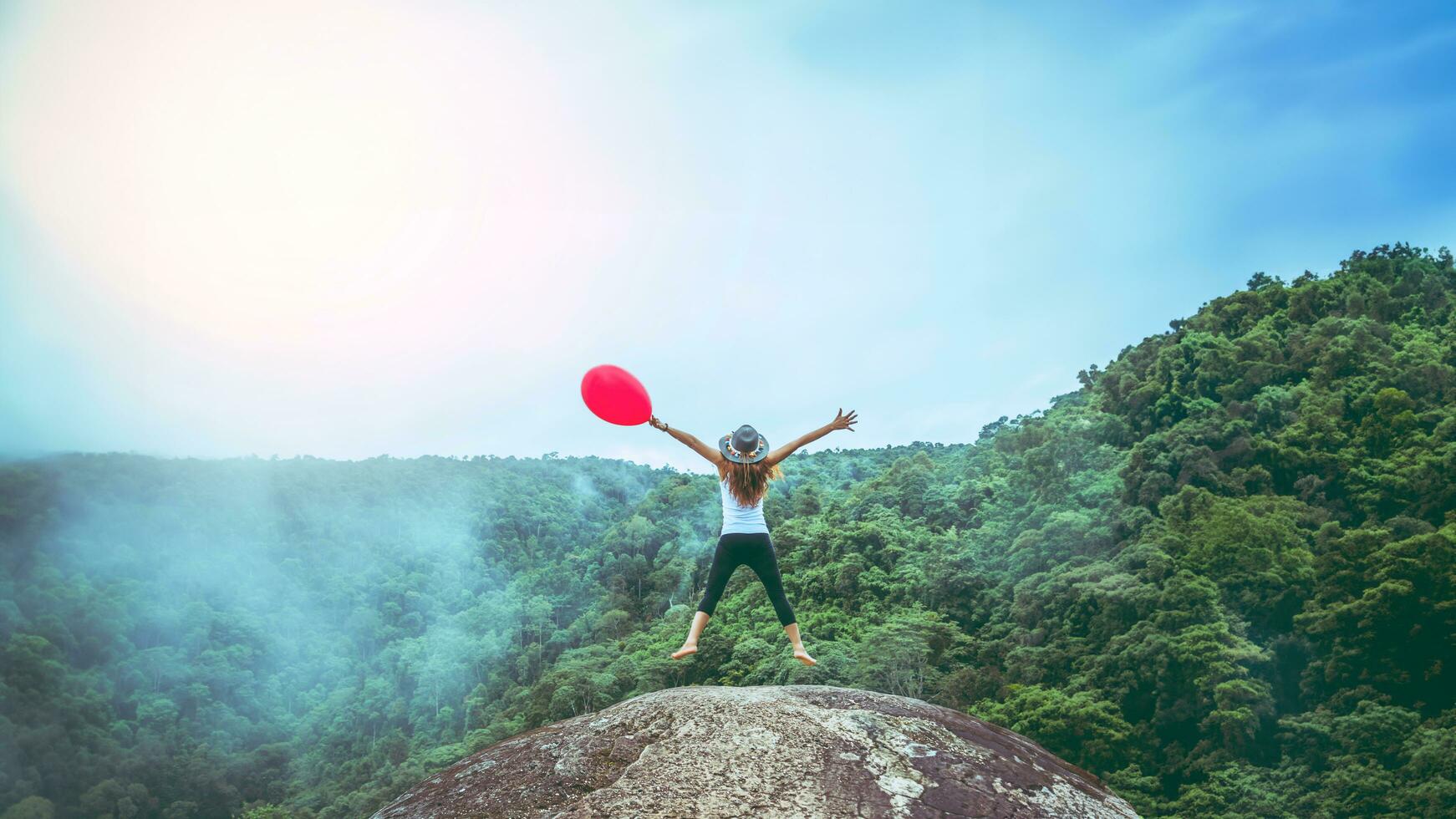 Asian women travel nature. Travel relax. Balloons in handAnd jump. Touch fog. photo