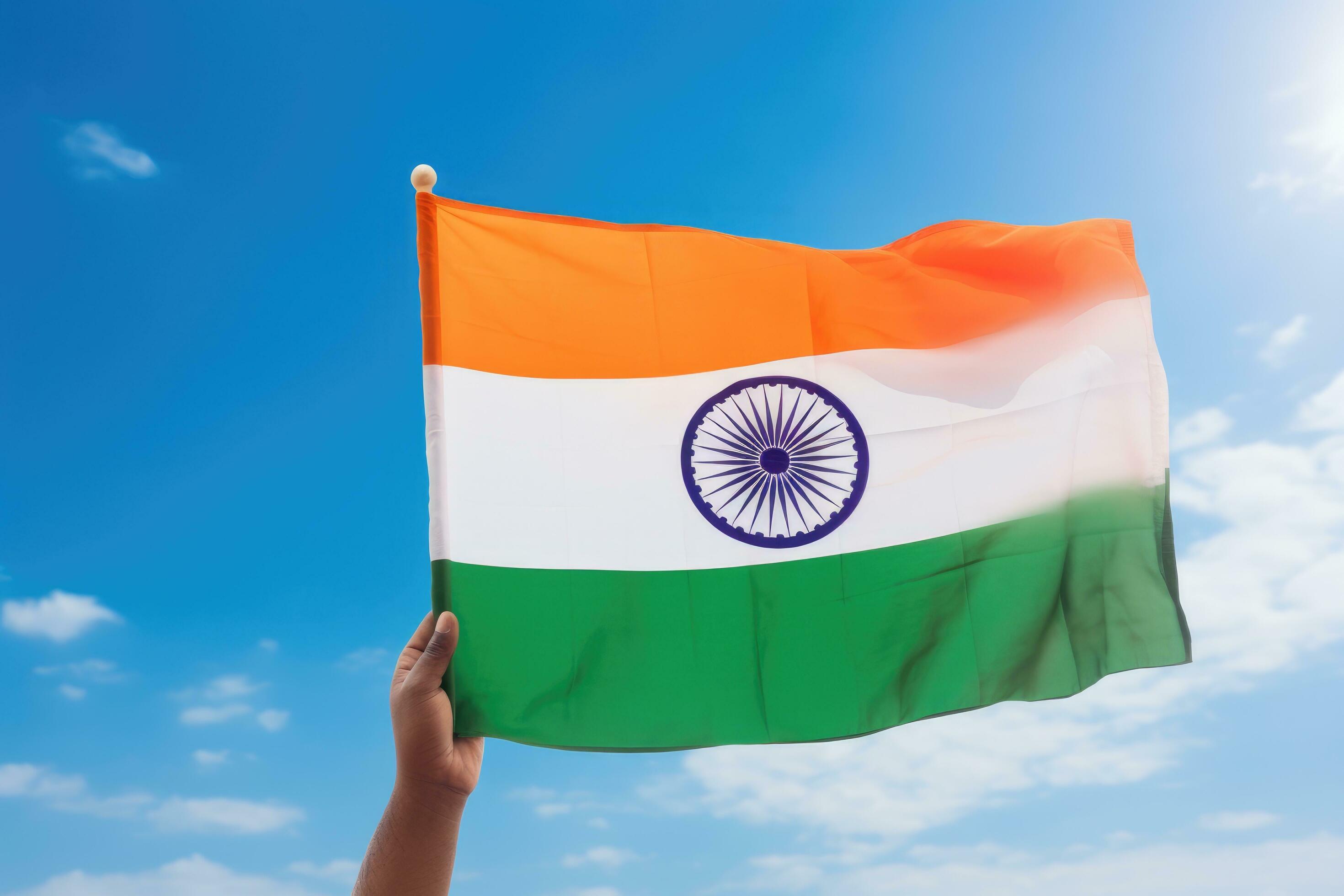 hand holding indian flag on blue sky background, independence day