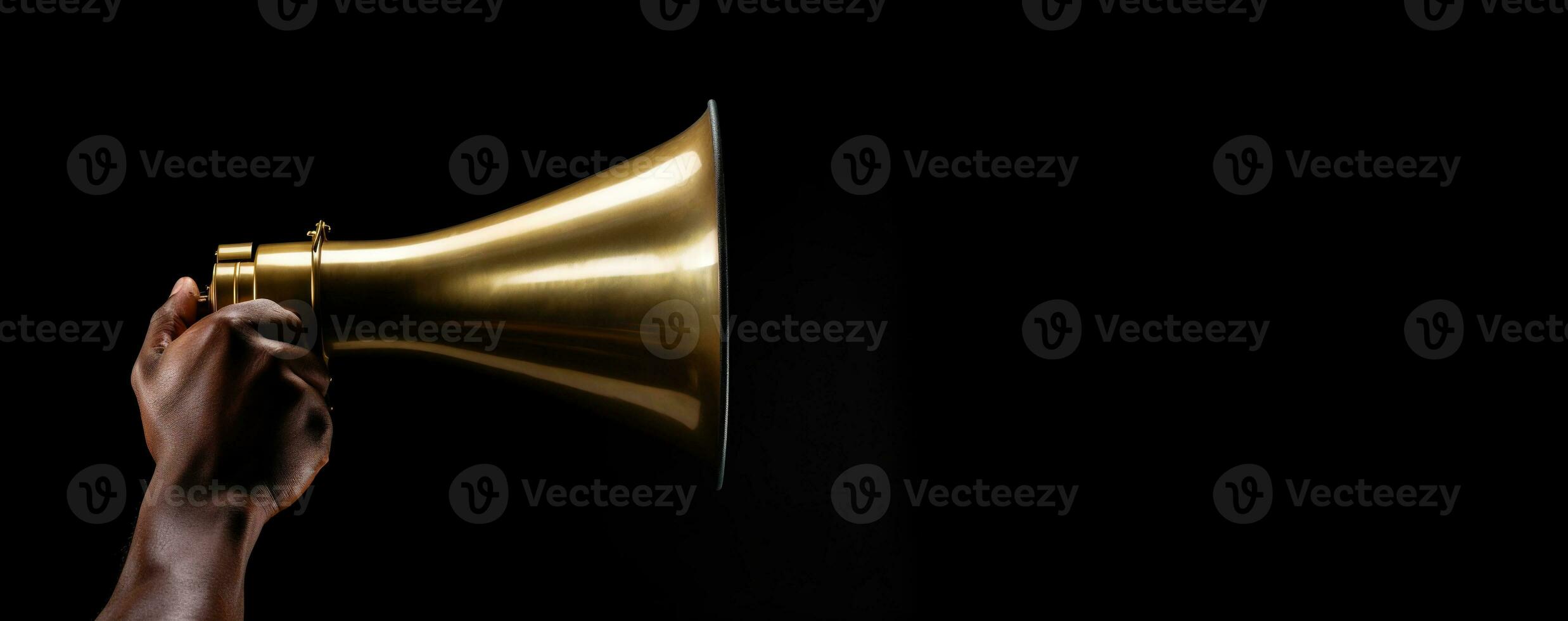 Generative AI, golden megaphone in hand on a empty black background, panoramic image with copy space photo