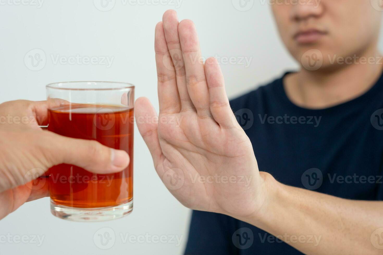 man refuses say no and avoid to drink an alcohol whiskey , stopping hand sign male, alcoholism treatment, alcohol addiction, quit booze, Stop Drinking Alcohol. Refuse Glass liquor, unhealthy, reject photo