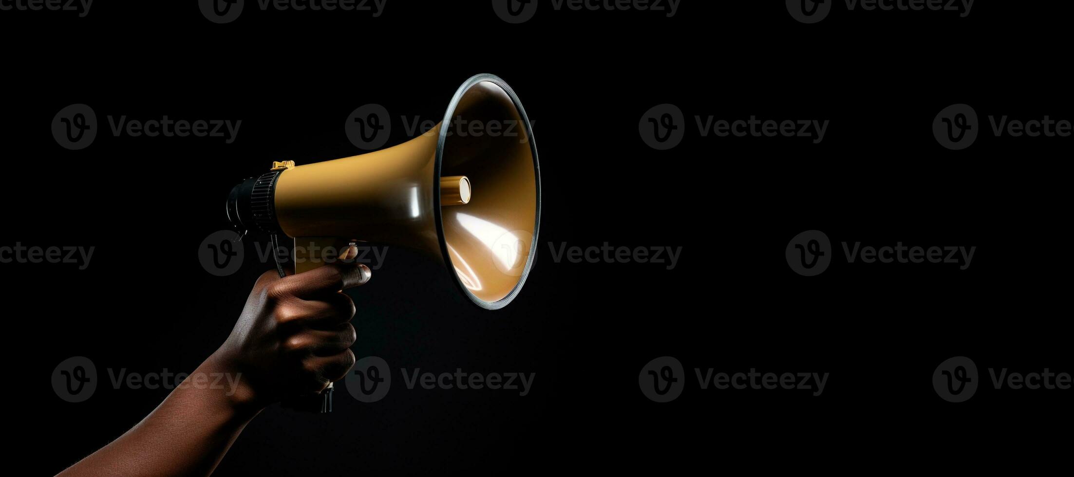 Generative AI, golden megaphone in hand on a empty black background, panoramic image with copy space photo