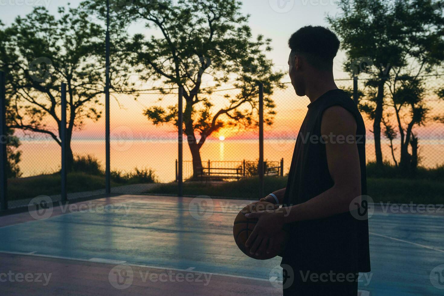 black man doing sports, playing basketball on sunrise, silhouette photo