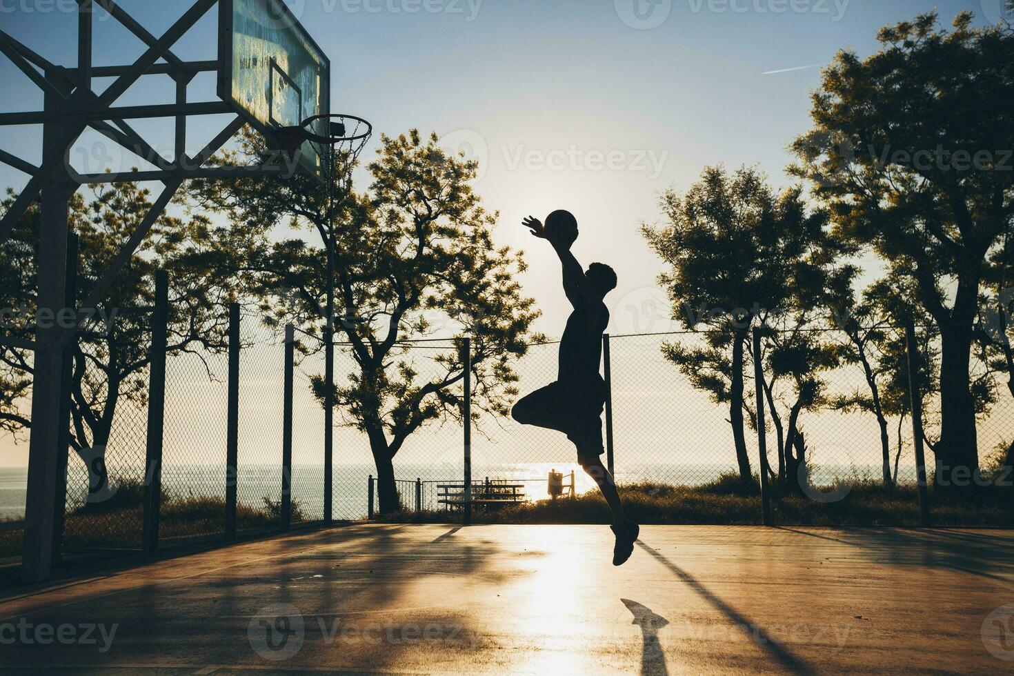 cool black man doing sports, playing basketball on sunrise, jumping silhouette photo