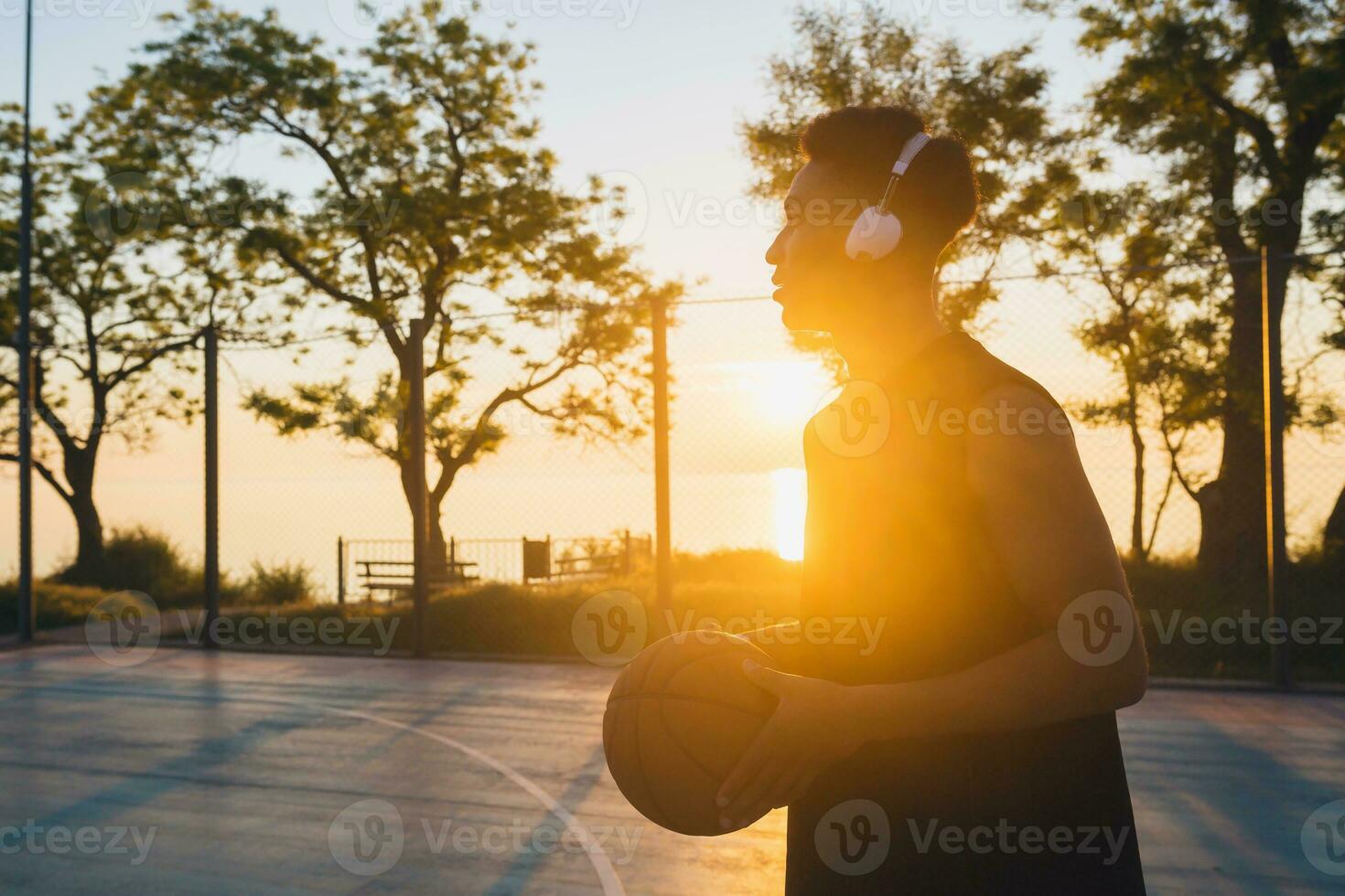 black man doing sports, playing basketball on sunrise, active lifestyle, sunny summer morning photo