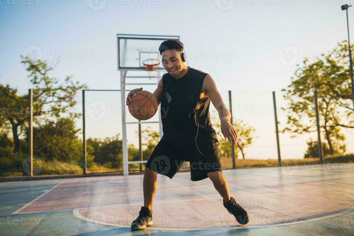 black man doing sports, playing basketball on sunrise, active lifestyle, sunny summer morning photo